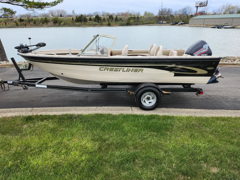 Slide: The Image of 2000 Crestliner 1850 Sportfish boat on trailer by a lake. - 10