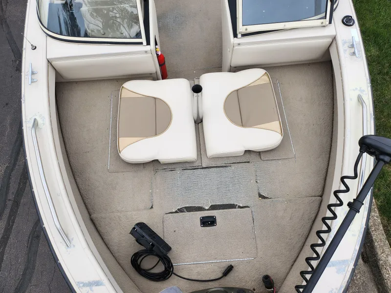 Slide: The Image of 2000 Crestliner 1850 Sportfish boat interior with beige seating and fishing equipment. - 18