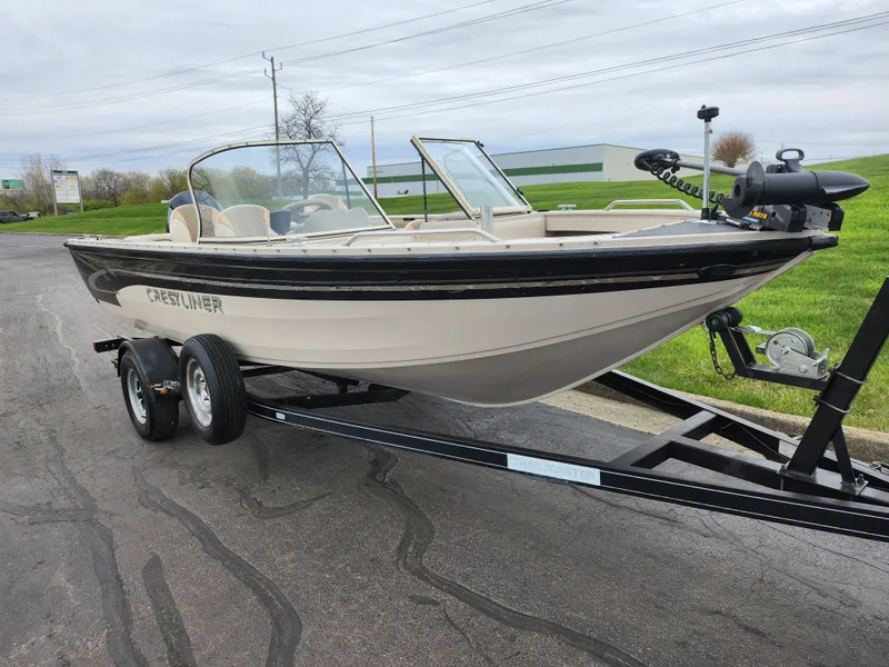 Slide: The Image of 2000 Crestliner 1850 Sportfish boat on trailer, parked on a paved road. - 5