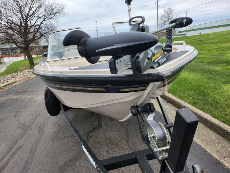 Slide: The Image of 2000 Crestliner 1850 Sportfish boat on trailer, parked on paved road near grassy area. - 6