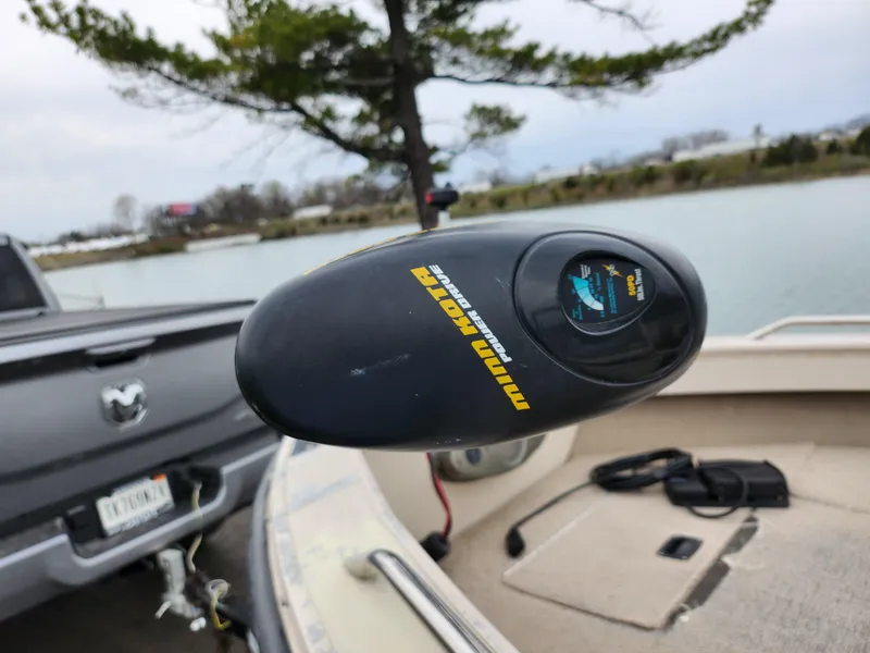 Slide: The Image of Minn Kota trolling motor on 2000 Crestliner 1850 Sportfish boat by a lakeside. - 8