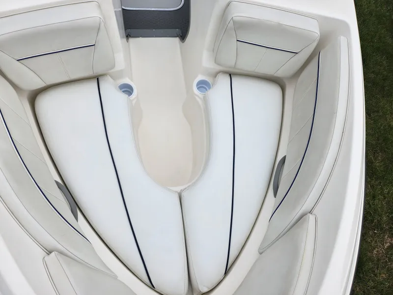 Slide: The Image of 2007 Bayliner Discovery 195 boat interior with white cushioned seating and cup holders. - 17