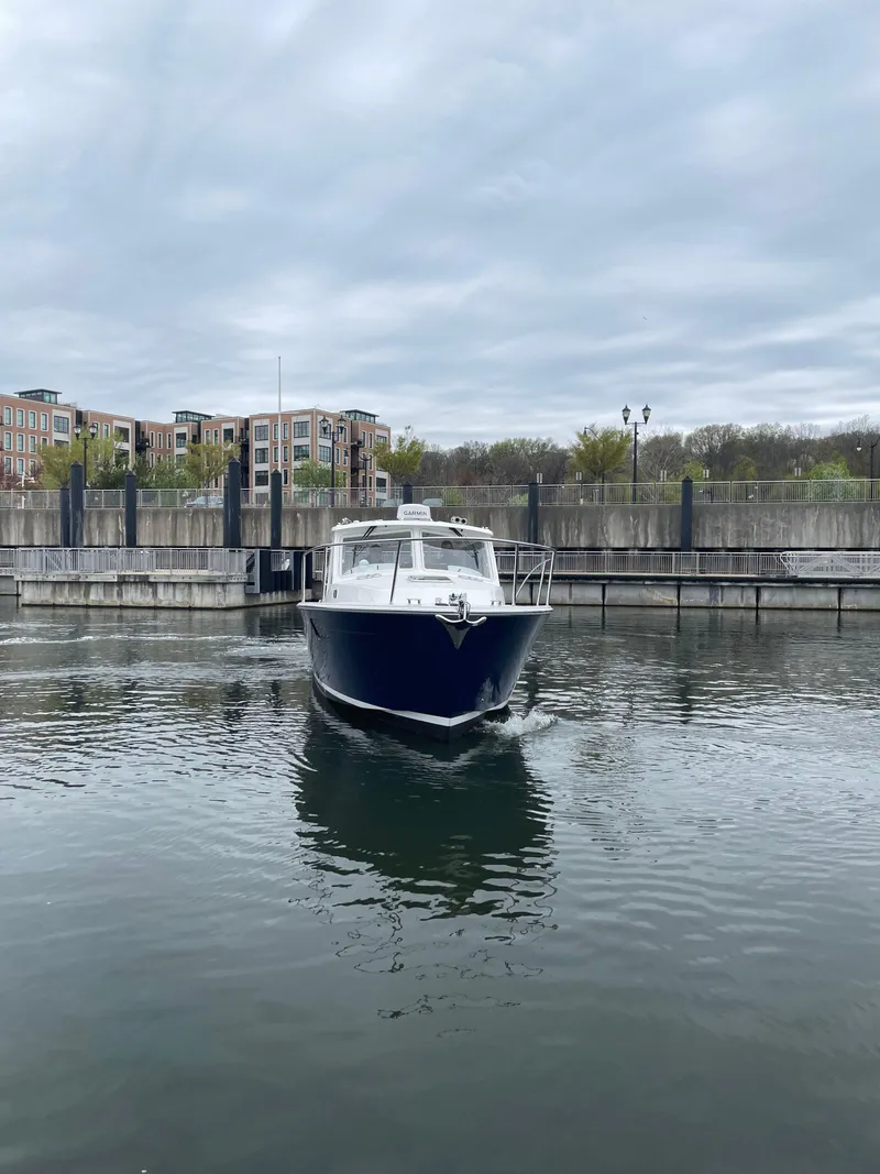 Slide: The Image of 2025 MJM 35 boat docked in a calm marina under cloudy skies. - 10
