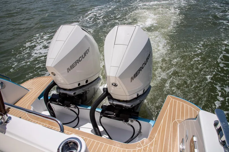 Slide: The Image of Twin Mercury outboard engines on a 2025 MJM 35 boat, cruising on water. - 16