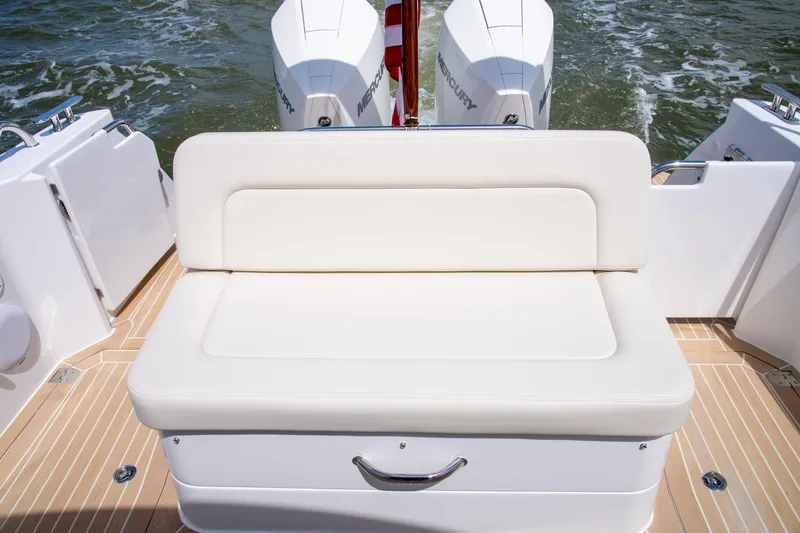 Slide: The Image of 2025 MJM 35 boat with cushioned seating and twin Mercury outboard engines. - 18