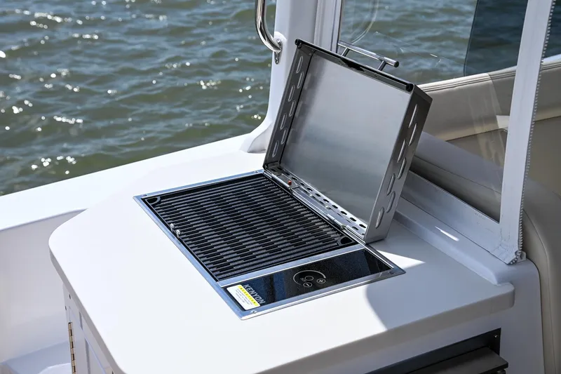 Slide: The Image of Built-in grill on 2025 MJM 35 boat, open lid, near water. - 20