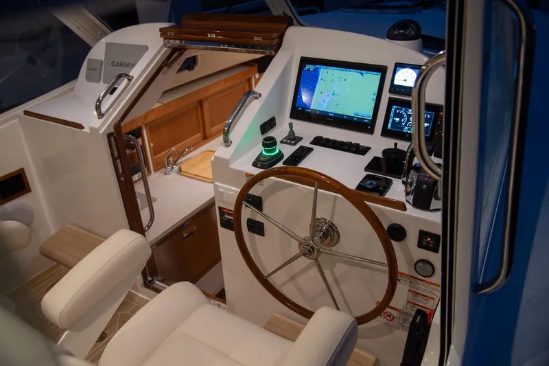 Slide: The Image of Helm of 2025 MJM 35 boat with modern navigation equipment and wooden steering wheel. - 29