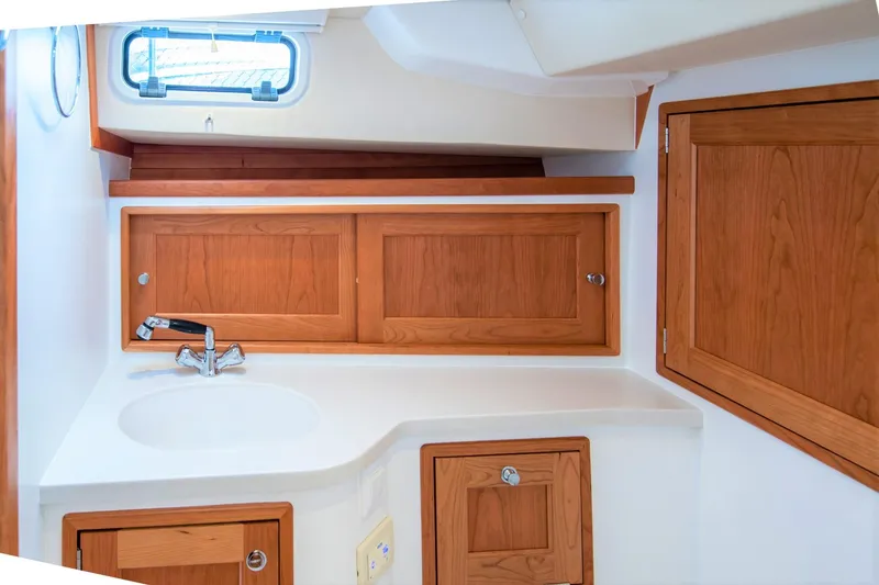 Slide: The Image of 2025 MJM 35 yacht interior with wooden cabinets and compact sink area. - 38
