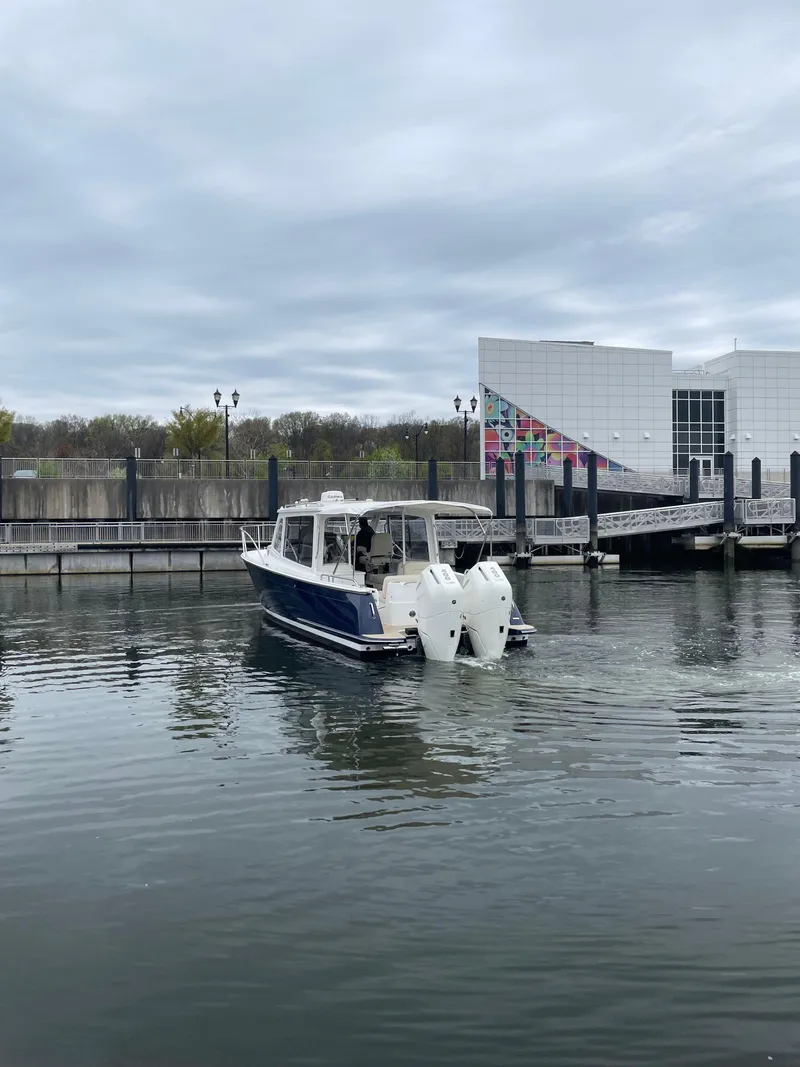 Slide: The Image of 2025 MJM 35 boat docked in a marina with modern building backdrop. - 4