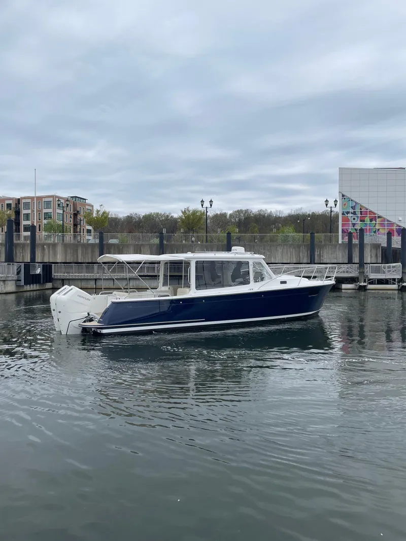 Slide: The Image of 2025 MJM 35 boat docked in a marina with modern buildings in the background. - 6