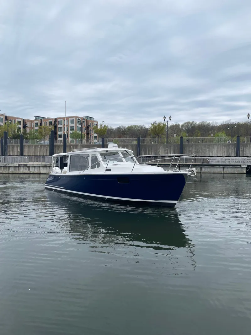 Slide: The Image of 2025 MJM 35 boat docked in a marina under cloudy skies. - 9