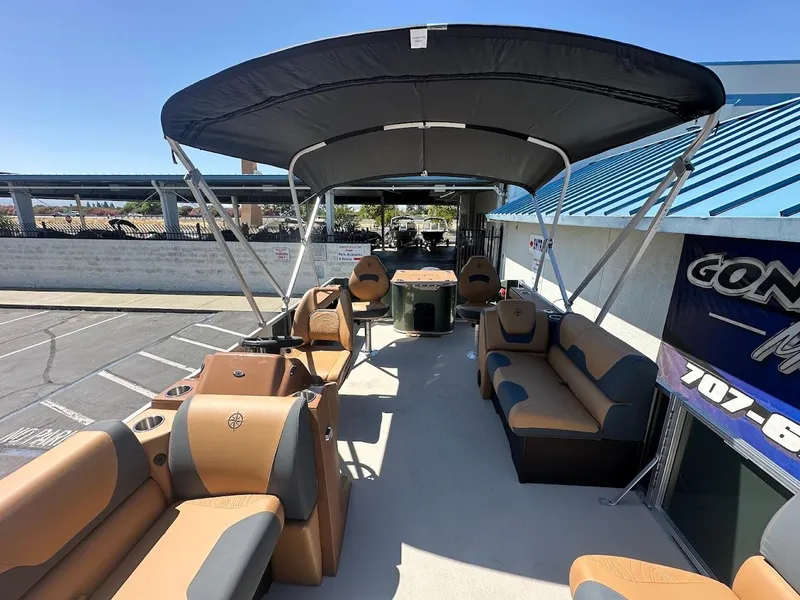 Slide: The Image of 2025 Tahoe Pontoon Geofish RF with spacious seating and canopy, parked outdoors. - 12