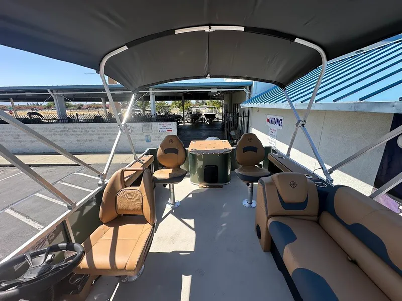 Slide: The Image of 2025 Tahoe Pontoon Geofish RF with spacious seating and canopy in a parking area. - 14
