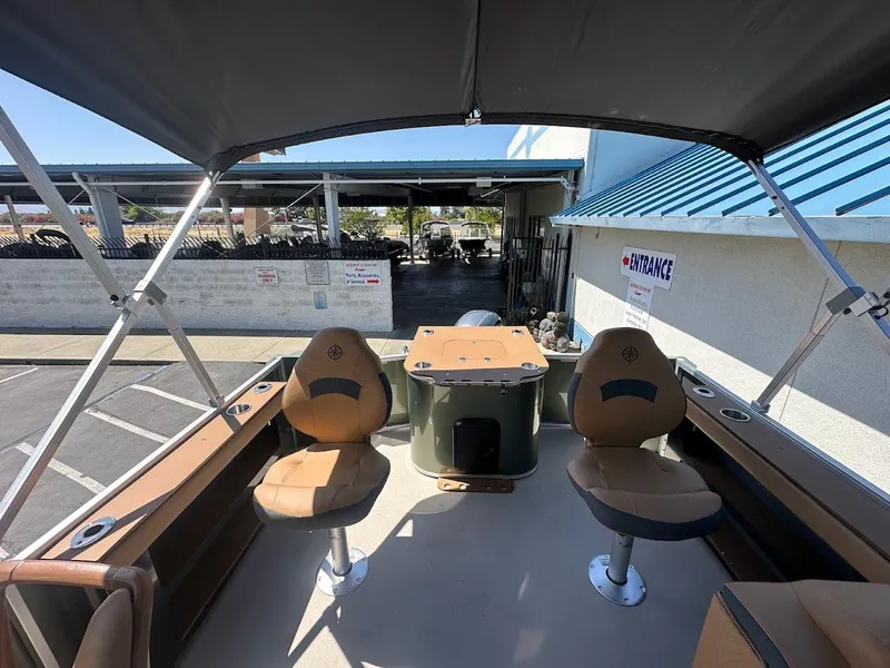 Slide: The Image of 2025 Tahoe Pontoon Geofish RF interior with seating and canopy in a parking area. - 15