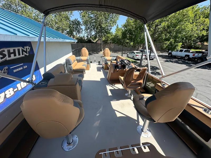 Slide: The Image of 2025 Tahoe Pontoon Geofish RF interior with tan seating and canopy, parked outdoors. - 17