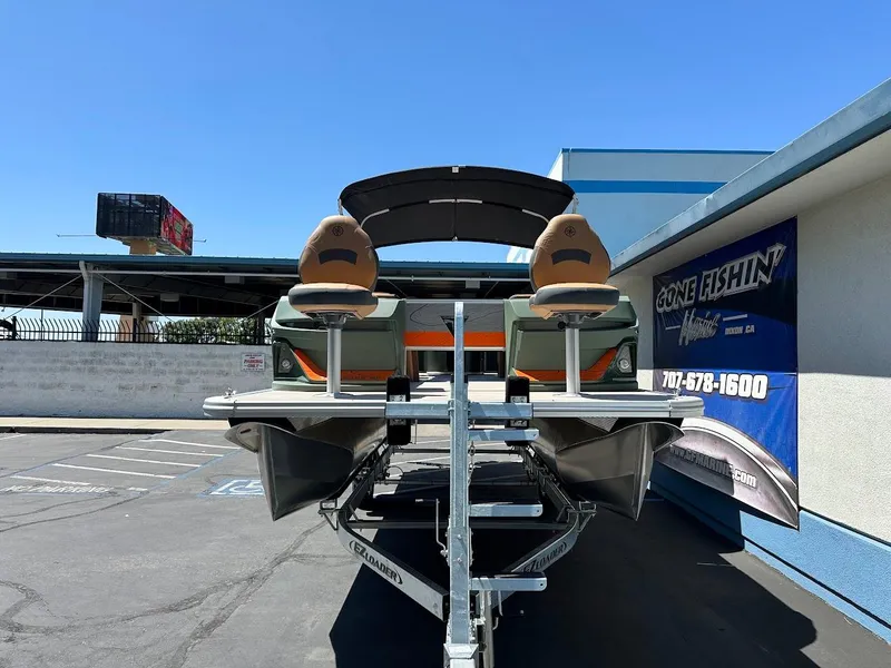 Slide: The Image of 2025 Tahoe Pontoon Geofish RF on trailer, parked outdoors under clear blue sky. - 2