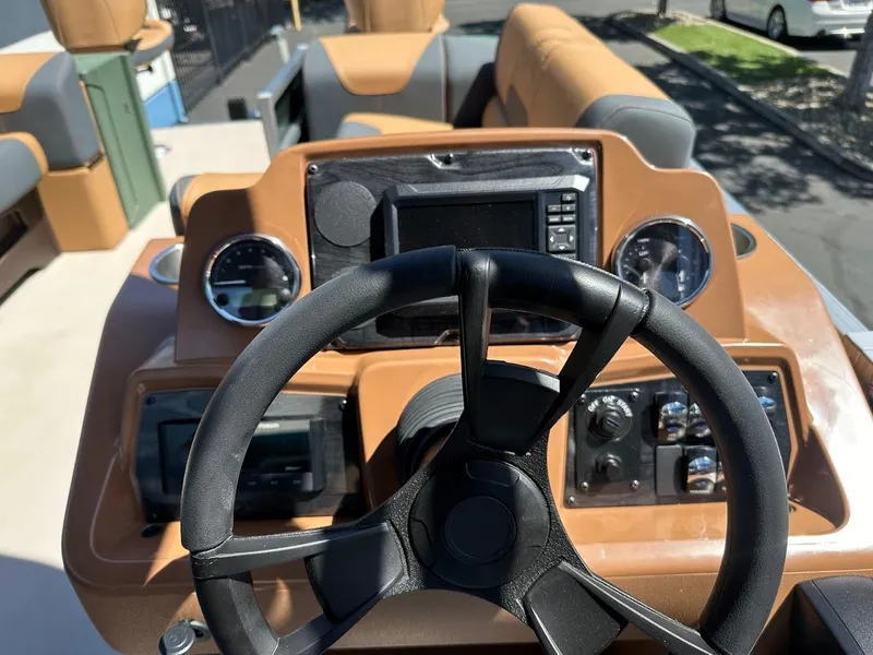 Slide: The Image of 2025 Tahoe Pontoon Geofish RF dashboard with steering wheel and control panel. - 22