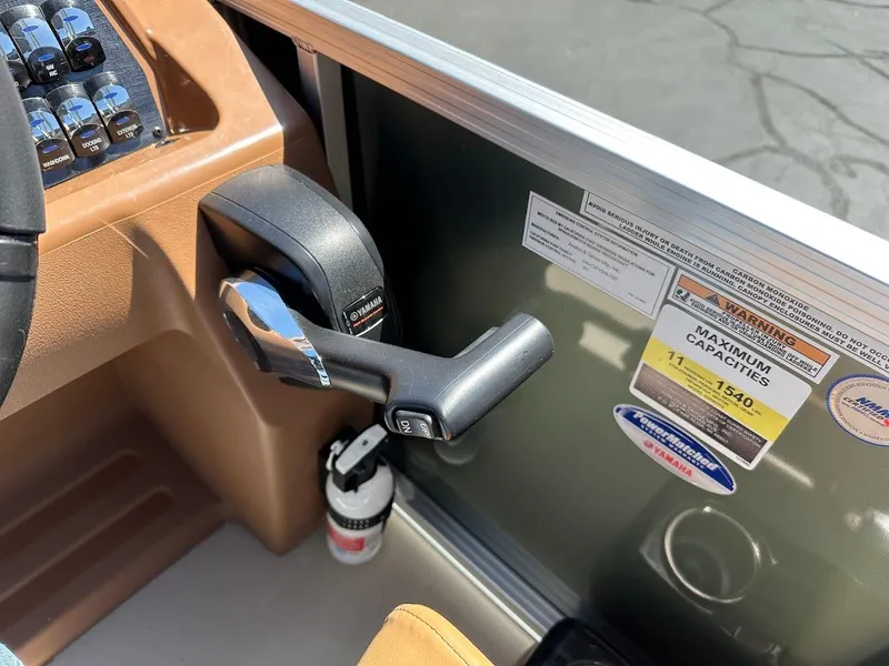 Slide: The Image of 2025 Tahoe Pontoon Geofish RF throttle control and capacity label in boat cockpit. - 25