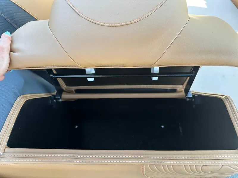 Slide: The Image of 2025 Tahoe Pontoon Geofish RF storage compartment with open tan leather seat. - 35