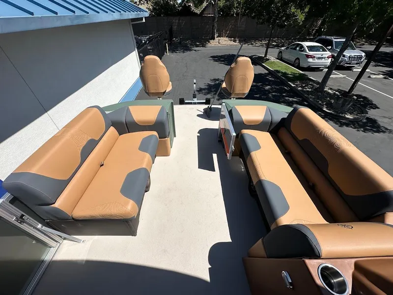 Slide: The Image of 2025 Tahoe Pontoon Geofish RF with tan and gray seating, parked outdoors. - 36