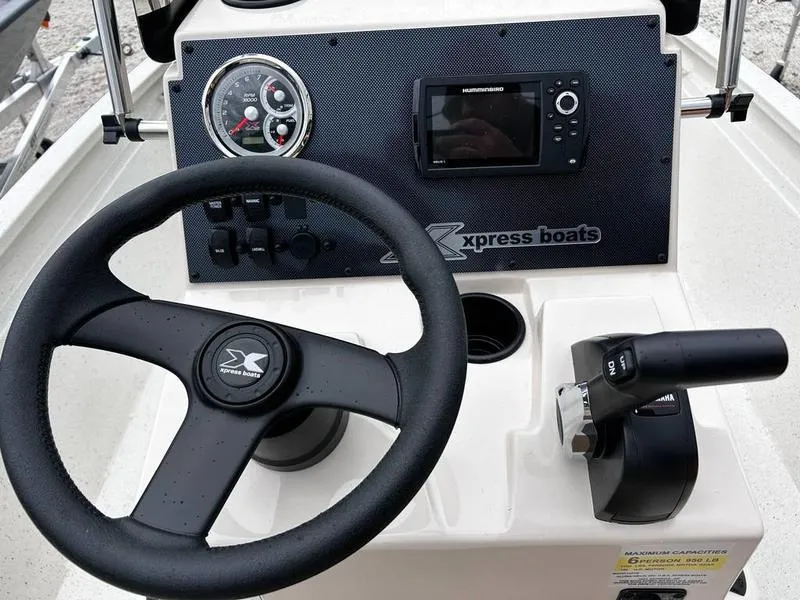 Slide: The Image of Steering console of 2025 Xpress H210B boat with controls and navigation display. - 11
