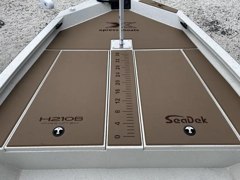 Slide: The Image of 2025 Xpress H210B boat deck with SeaDek padding and measurement markings. - 13