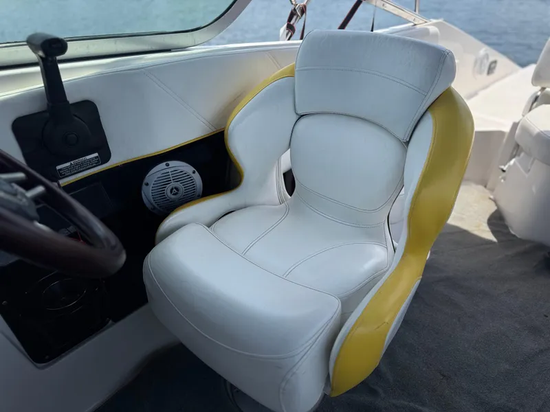Slide: The Image of Captain's chair on 2008 Regal 2520 FasDeck boat, featuring white and yellow upholstery. - 11