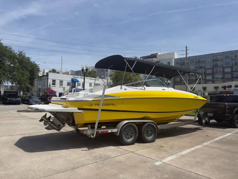 Slide: The Image of Yellow 2008 Regal 2520 FasDeck boat on trailer in urban parking lot. - 2