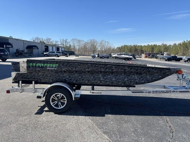 Slide: The Image of 2025 Havoc 1656 VJST boat on trailer, parked outdoors under clear blue sky. - 7