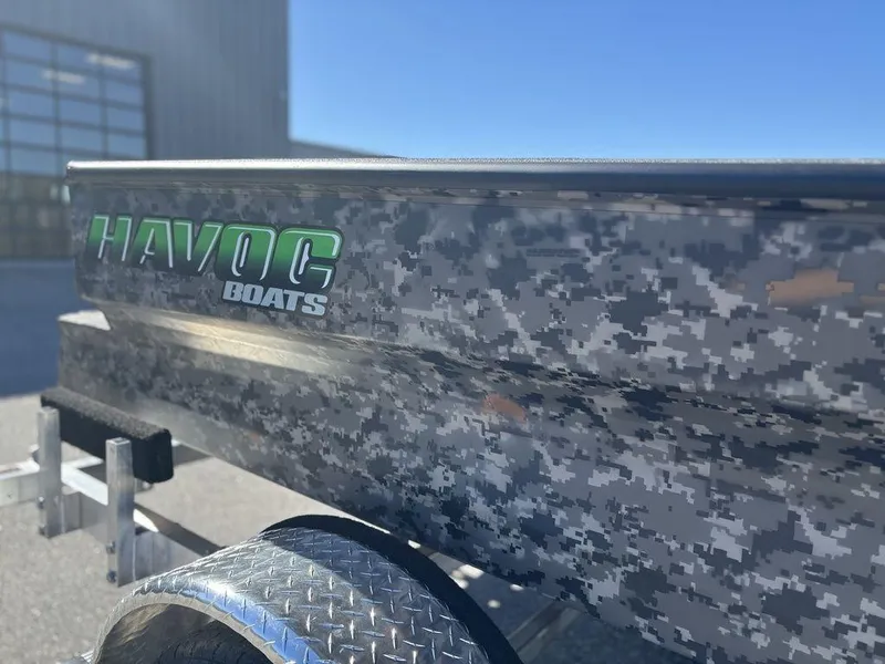 Slide: The Image of 2025 Havoc 1656 VJST boat with digital camouflage design and logo, parked outdoors. - 8