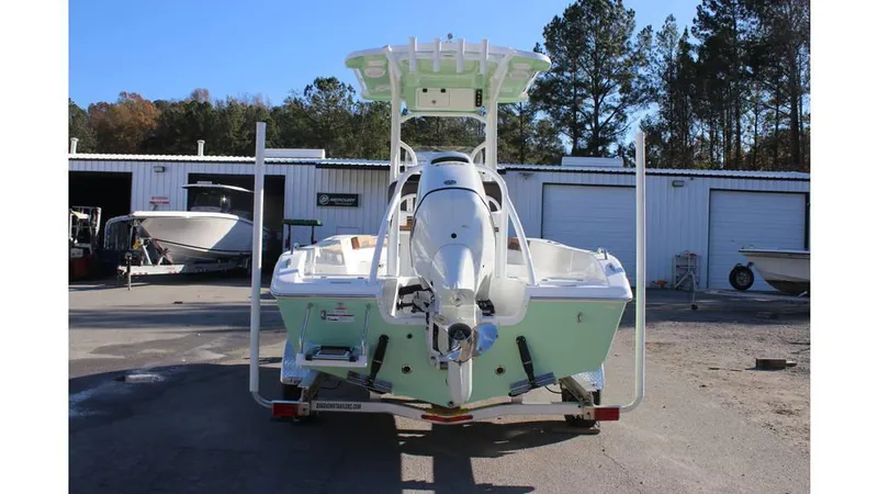 Slide: The Image of 2025 Sea Pro 202 CC boat, rear view, parked outdoors near storage units. - 12