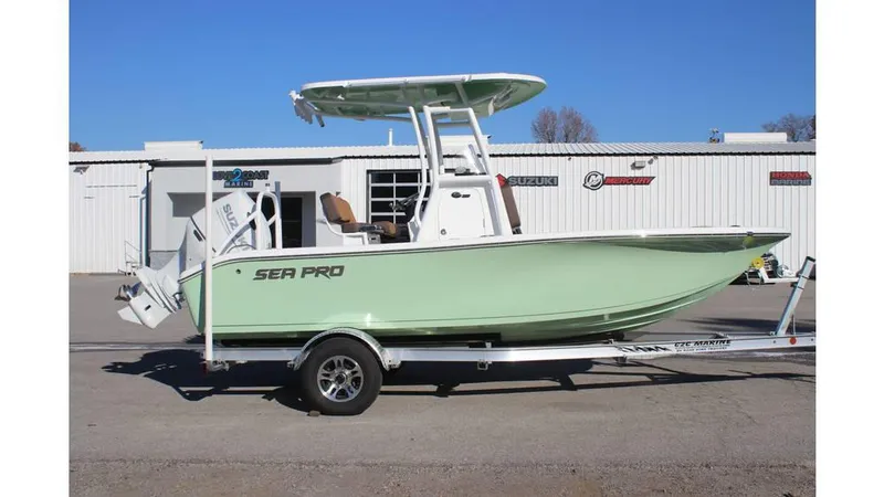 Slide: The Image of 2025 Sea Pro 202 CC boat on trailer, light green hull, parked outside dealership. - 2