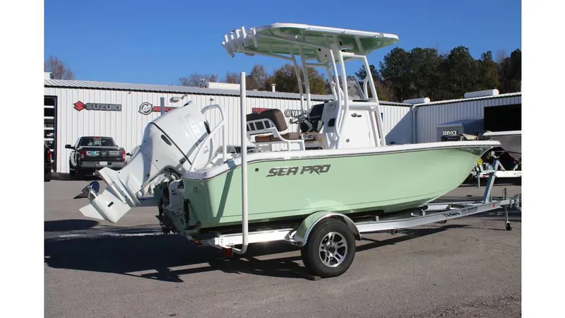 Slide: The Image of 2025 Sea Pro 202 CC boat on trailer, parked outdoors near service center. - 3
