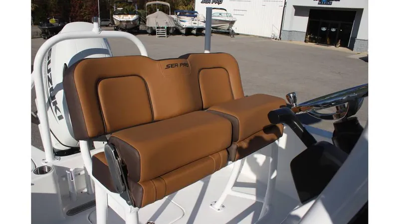 Slide: The Image of 2025 Sea Pro 202 CC boat with brown cushioned seating and steering console. - 9
