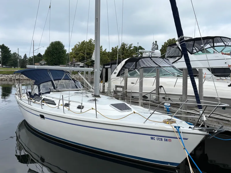 Slide: The Image of Catalina 36MKII 2002 sailboat docked at marina, featuring blue canopy and sleek design. - 2