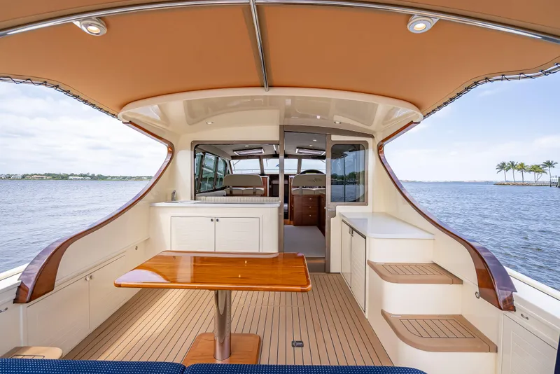Slide: The Image of 2018 Palm Beach Motor Yachts PB45 interior with elegant wood table and ocean view. - 13