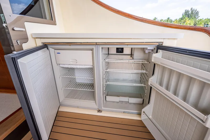 Slide: The Image of Open refrigerator on 2018 Palm Beach Motor Yachts PB45, showcasing spacious interior and shelving. - 19