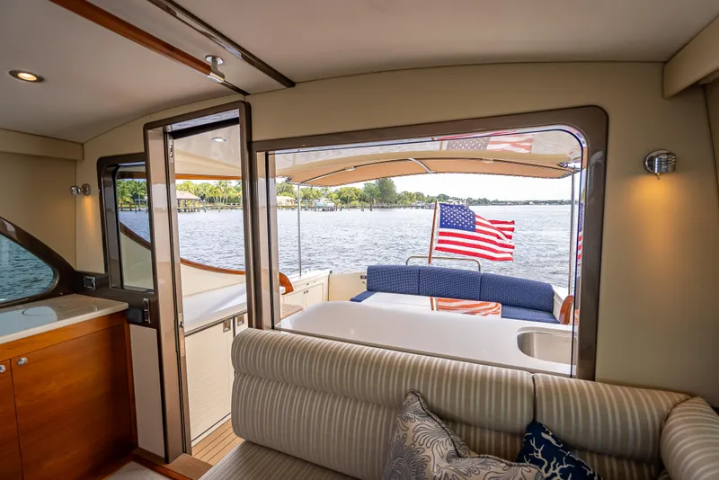Slide: The Image of Interior view of 2018 Palm Beach Motor Yachts PB45 with American flag and waterfront. - 24