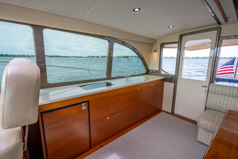 Slide: The Image of Interior of 2018 Palm Beach Motor Yachts PB45, featuring elegant wood cabinetry and large windows. - 33
