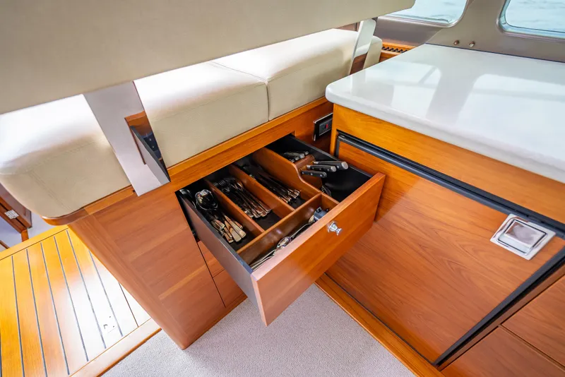 Slide: The Image of 2018 Palm Beach Motor Yachts PB45 interior with open wooden drawer and cutlery. - 36