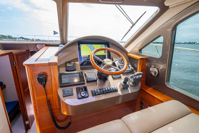 Slide: The Image of Helm of 2018 Palm Beach Motor Yachts PB45 with navigation equipment and wooden steering wheel. - 45