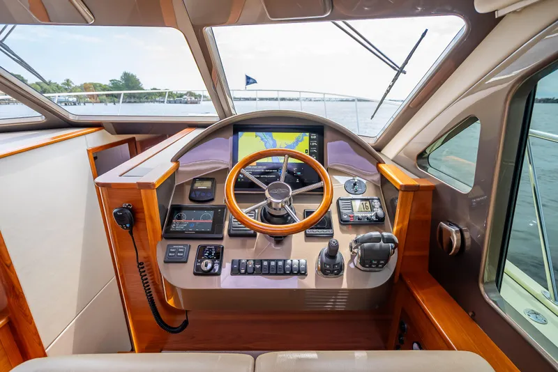 Slide: The Image of Helm of 2018 Palm Beach Motor Yachts PB45 with wooden steering wheel and navigation controls. - 46