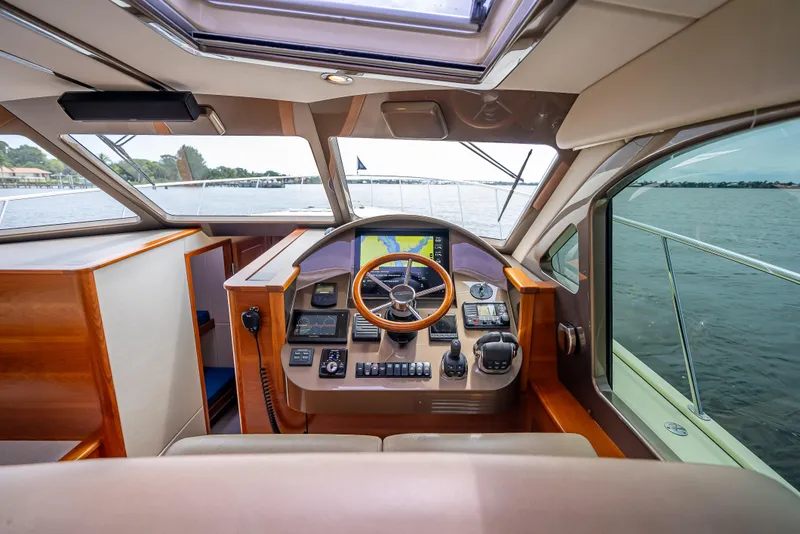 Slide: The Image of Helm of 2018 Palm Beach Motor Yachts PB45, featuring modern navigation equipment and wooden steering wheel. - 47