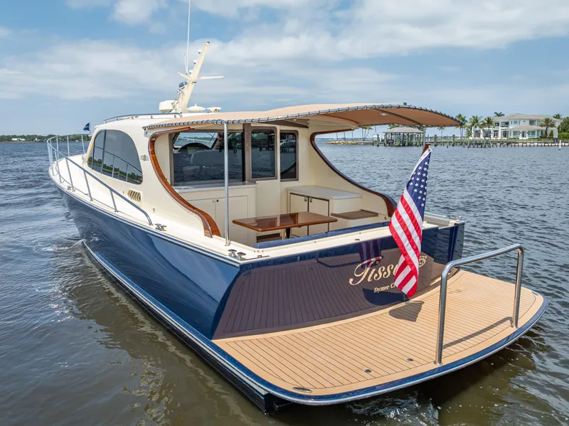 Slide: The Image of 2018 Palm Beach Motor Yachts PB45 cruising on water, rear view with American flag. - 7
