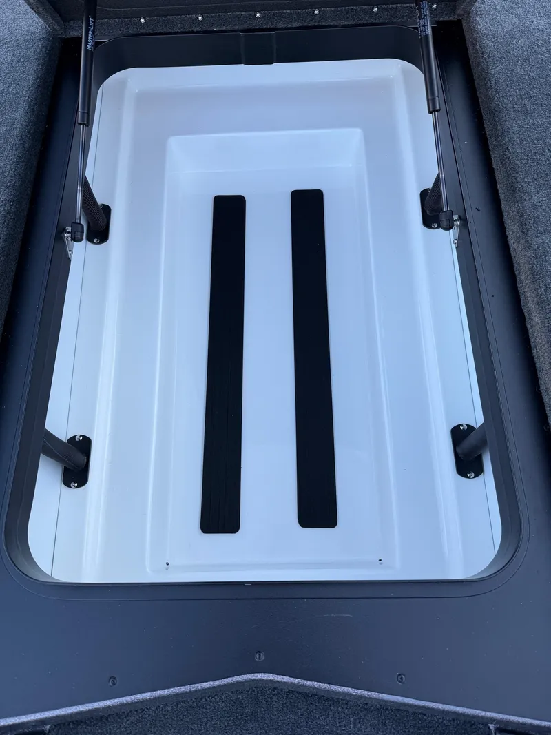 Slide: The Image of 2025 Skeeter ZXR 20 SE boat storage compartment with black support bars. - 17