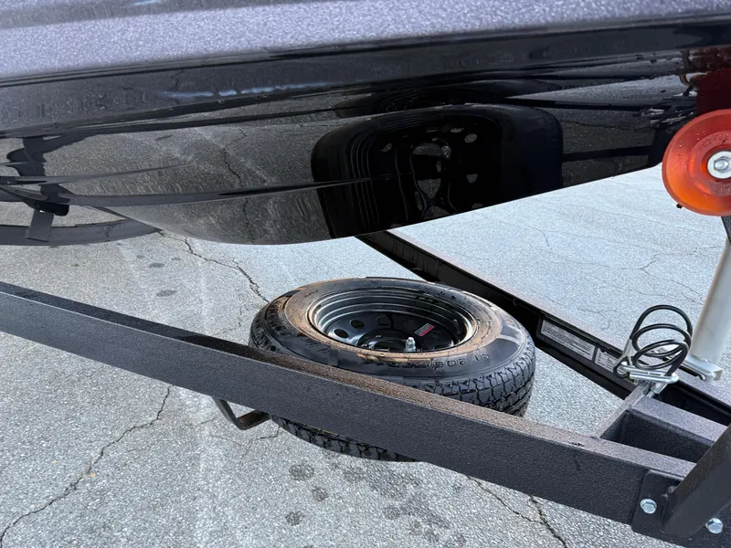 Slide: The Image of 2025 Skeeter ZXR 20 SE boat trailer with spare tire on pavement. - 4