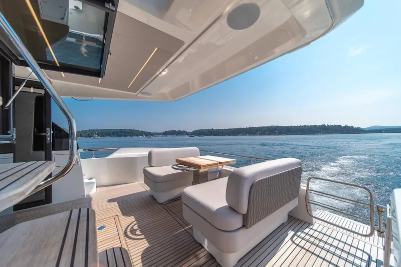 Slide: The Image of Luxurious 2025 Prestige F4.9 yacht deck with seating, overlooking serene waters. - 21