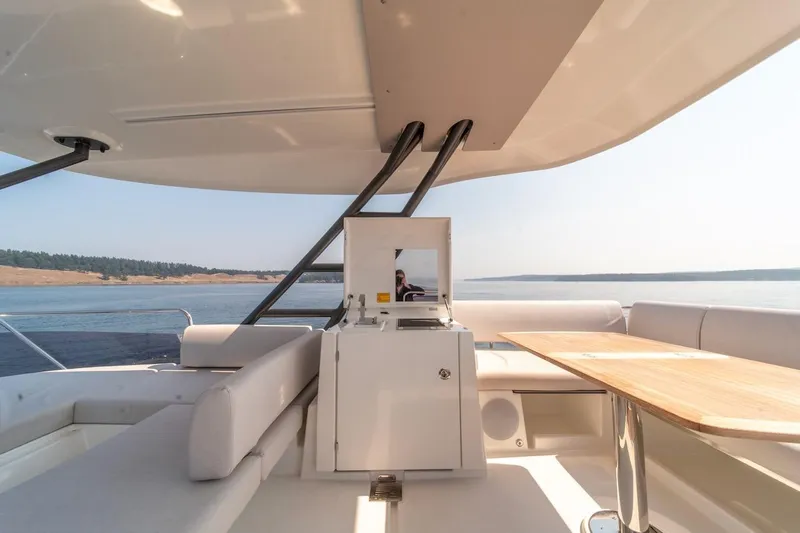 Slide: The Image of Luxurious Prestige F4.9 yacht interior, 2025 model, featuring elegant seating and scenic ocean view. - 22