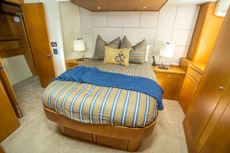 Slide: The Image of Luxurious bedroom interior of 2003 Donzi R65 yacht with striped bedding and wooden cabinetry. - 11