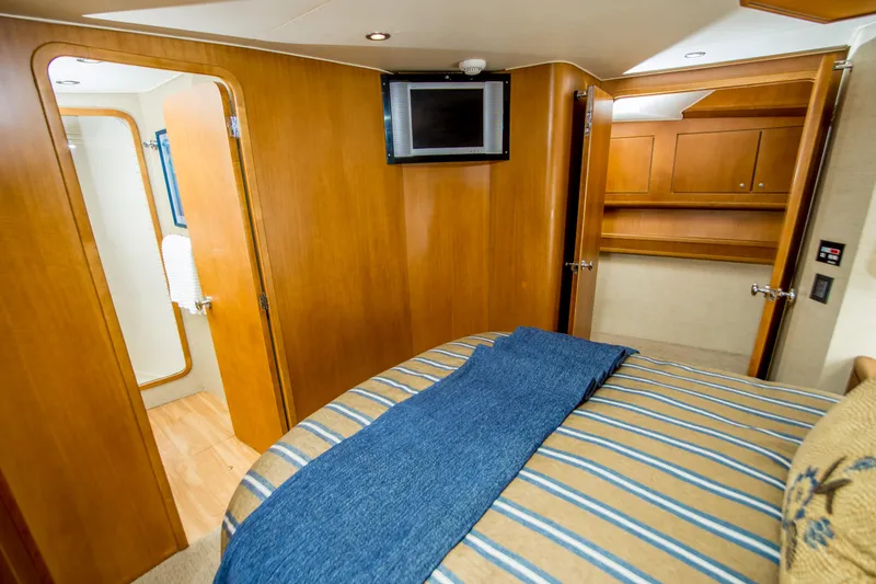 Slide: The Image of Interior of 2003 Donzi R65 yacht cabin with bed, TV, and wooden cabinetry. - 12